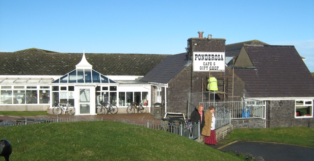 the pnderosa cafe in the sun, a large stone building on a hilltop with large conservatories